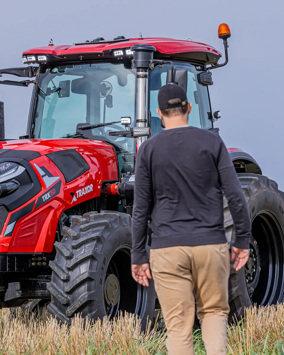 Productor caminando hacia un TRAXOR TRX150 en el campo