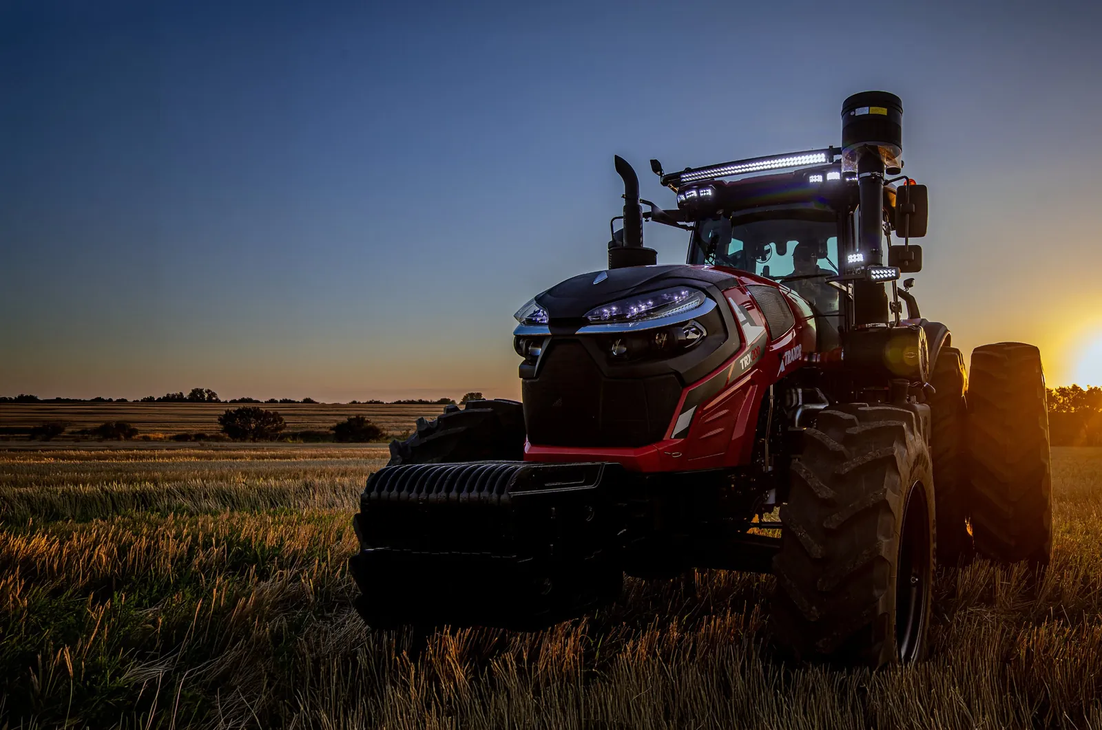 TRAXOR TRX200 con las luces encendidas en el lote al atardecer